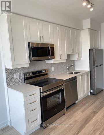Pickering (Bay Ridges) condo for rent - A kitchen with white cabinets and a black refrigerator.