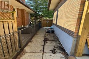Toronto (West Hill) apartment for rent - A narrow alley with a fence on the left side and a brick building on the right.