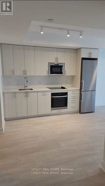 Oshawa (Windfields) condo for rent - A modern kitchen with white cabinets and stainless steel appliances.