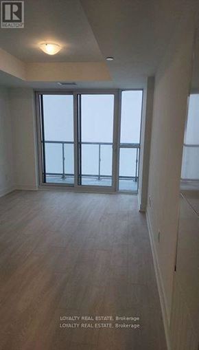 Oshawa (Windfields) condo for rent - A room with a window and wooden floors.