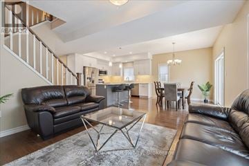 Owen Sound apartment for rent - A living room with a black leather couch and a glass coffee table.
