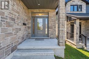 Owen Sound apartment for rent - A house entrance with a grey door and a stone wall.