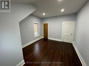 Innisfil (Churchill) apartment for rent - A room with wooden floors and white walls, with a door on the right and a window on the left.