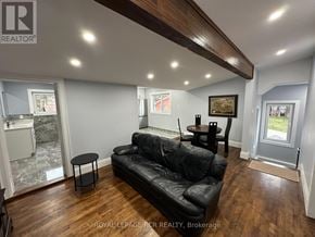Innisfil (Churchill) apartment for rent - A black leather couch sits in a well-lit room with wooden floors and a marble countertop.
