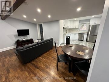 Innisfil (Churchill) apartment for rent - A living room with a black couch and a wooden table.