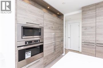 Burnaby apartment for rent - A modern kitchen with a stainless steel oven and wooden cabinets.