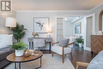 Milton (Tm Timberlea) apartment for rent - A living room with a grey couch, a wooden coffee table, a white chair, and a painting on the wall.