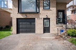 Milton (Tm Timberlea) apartment for rent - A house with a black garage door and a brick facade.