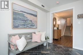 Milton (Tm Timberlea) apartment for rent - A grey bench with pink and white pillows in a room with a painting of a beach scene on the wall.