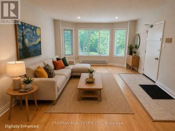 Toronto (Annex) apartment for rent - A well-lit living room with a white sofa, wooden coffee table, and a painting on the wall.