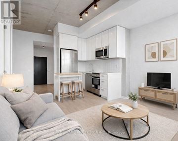 Toronto (Moss Park) condo for rent - A modern living room with a grey couch and a wooden coffee table.
