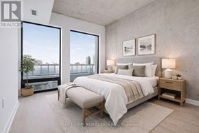Toronto (Moss Park) condo for rent - A bedroom with a large bed and a view of the city.