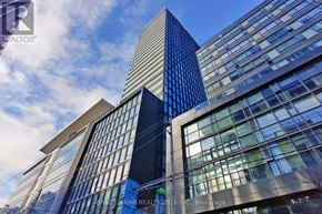 Toronto (Moss Park) condo for rent - A tall building with a blue glass facade stands next to a shorter building with a white facade.