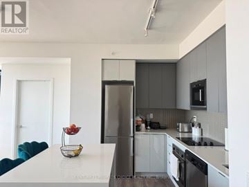 Vaughan (Concord) condo for rent - A modern kitchen with a white countertop and grey cabinets.