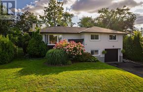 Barrie (Wellington) apartment for rent - A house with a well-maintained lawn and a flower bed in front.