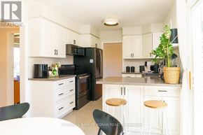 Barrie (Wellington) apartment for rent - A kitchen with white cabinets and black appliances.