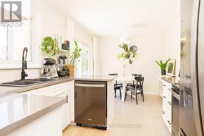 Barrie (Wellington) apartment for rent - A modern kitchen with a refrigerator, sink, and dining table.