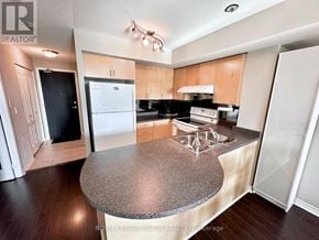 Toronto (Bayview Village) condo for rent - A kitchen with a granite countertop and wooden cabinets.