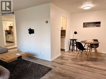 Windsor condo for rent - A living room with a black chair and a black table with a lamp on it.