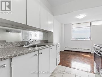 Toronto (Weston) condo for rent - A kitchen with white cabinets and a granite countertop.