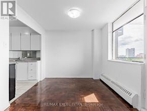 Toronto (Weston) condo for rent - A spacious, empty room with a window overlooking a cityscape.
