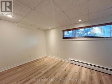 St. Catharines (Burleigh Hill) apartment for rent - A room with wooden flooring and a window with blinds.