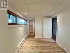 St. Catharines (Burleigh Hill) apartment for rent - A white interior room with wooden floors and a doorway leading to another room.
