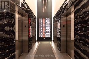 Toronto (Waterfront Communities) condo for rent - A hallway with marble walls and elevators on either side.