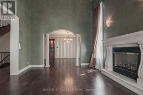 Mississauga (Lorne Park) apartment for rent - A spacious room with a fireplace and a chandelier.