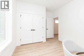 Lethbridge apartment for rent - A white chair is in a white room with a white door and a white cabinet.