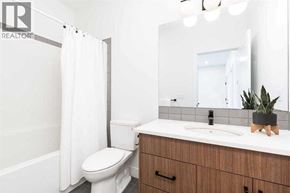Lethbridge apartment for rent - A bathroom with a toilet, sink, and mirror.