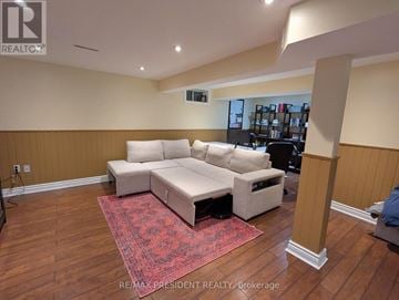 Burlington (Brant Hills) apartment for rent - A living room with a white couch and a red rug.