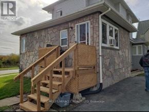 Oshawa (Central) apartment for rent - A stone house with a wooden staircase leading to a door.