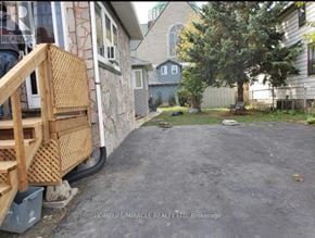 Oshawa (Central) apartment for rent - A backyard with a wooden deck and a tree.