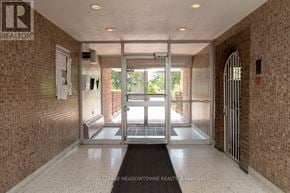 Mississauga (Port Credit) multi-family for rent - A hallway with a brick wall and a glass door leading outside.