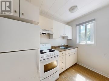 Halton Hills (Georgetown) multi-family for rent - A white kitchen with a stove and cabinets.