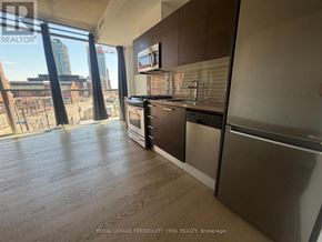 Toronto (Moss Park) condo for rent - A kitchen with wooden floors and stainless steel appliances.