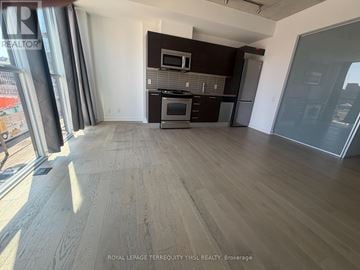 Toronto (Moss Park) condo for rent - A kitchen with dark brown cabinets and stainless steel appliances.