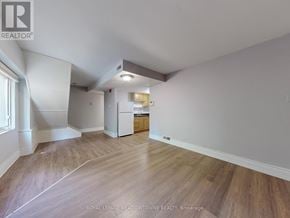 Halton Hills (Georgetown) multi-family for rent - A spacious room with wooden flooring and white walls.