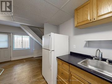 Halton Hills (Georgetown) multi-family for rent - A kitchen with a white refrigerator and wooden cabinets.