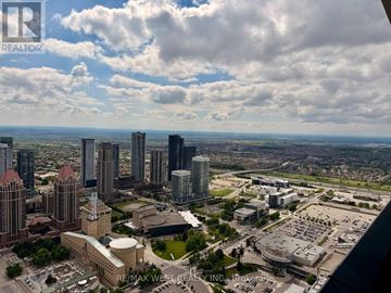 Mississauga (City Centre) condo for rent - A cityscape with tall buildings and a cloudy sky.