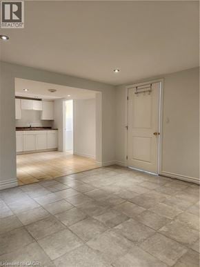 Thorold apartment for rent - A spacious room with a tiled floor and a door leading to another room.