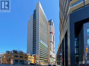 Toronto (Waterfront Communities) condo for rent - A tall building with a glass facade stands in the middle of a city street.