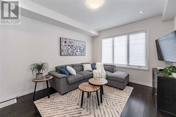 Hamilton (Meadowlands) townhouse for rent - A living room with a grey couch, a coffee table, and a painting on the wall.