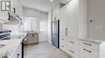 Toronto (Parkwoods-Donalda) apartment for rent - A kitchen with white cabinets and a marble countertop.