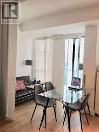 Toronto (Don Valley Village) condo for rent - A dining room with a glass table and chairs.