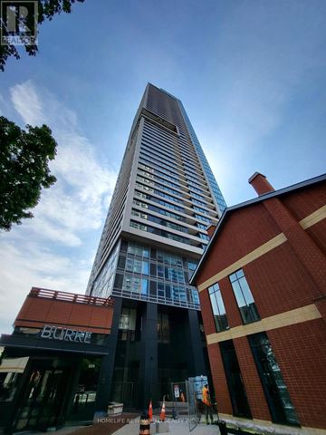 Toronto (North St. James Town) condo for rent - A tall building with a glass facade stands next to a brick building with a Burger King restaurant in front.