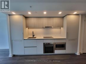 Toronto (North St. James Town) condo for rent - A modern kitchen with white cabinets and stainless steel appliances.