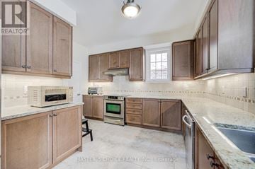 Markham (Cathedraltown) apartment for rent - A kitchen with wooden cabinets and a marble countertop.