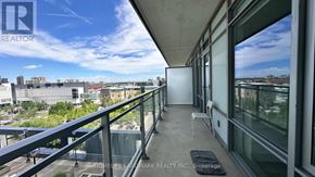 Mississauga (City Centre) condo for rent - A balcony with a chair and a table is overlooking a cityscape.